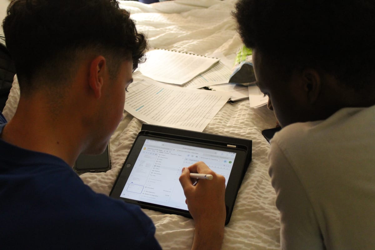 Two students working through a design together on a tablet